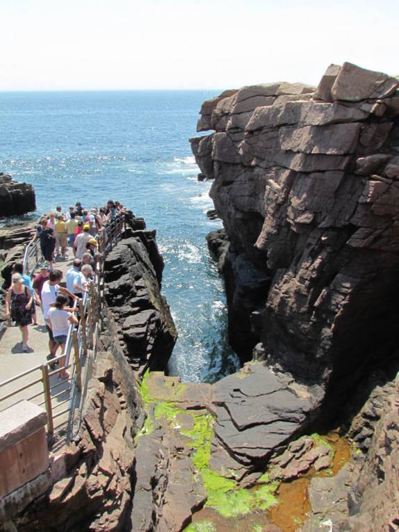 Turistas examinam formação rochosa no litoral do Acadia National Park, no Maine - Estados Unidos